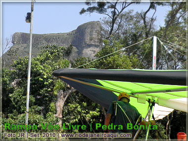 Piloto de asa delta prepara o v&ocirc;o tendo a Pedra da G&aacute;vea ao fundo